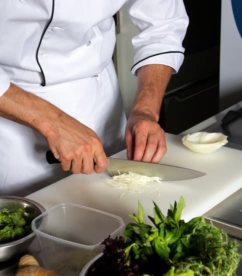 Chef cortando cebolla en la cocina